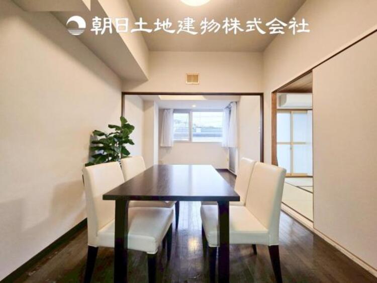 居間 【リビング】温かい色合いのフローリングと清々しい爽やかなクロスが明るい空間を創り出しているダイニングキッチン。ゆっくりと過ごす空間に相応しく、ここで楽しむ時間が家族や友人との絆をより深めてくれそうです。