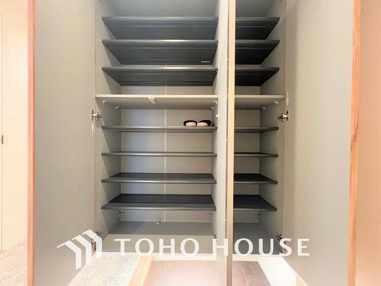 玄関 天井まである玄関収納はご家族分の履物も余裕で収納可能