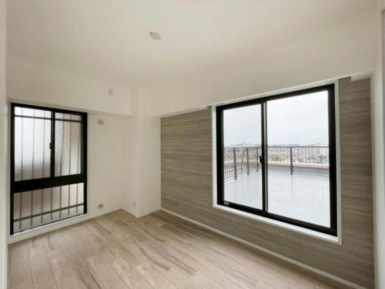 内装 バルコニーに面した大きな窓から陽光と風を受け止める、明るい洋室です