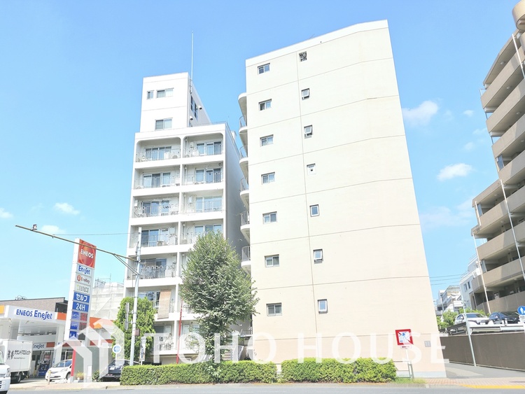 外観 通りに面した、白を基調とした清潔感のあるマンションです。曲線を描く手すりがスタイリッシュな印象を与えます。駅からも近く、周辺にはスーパーや商店街があり、生活しやすい環境です。