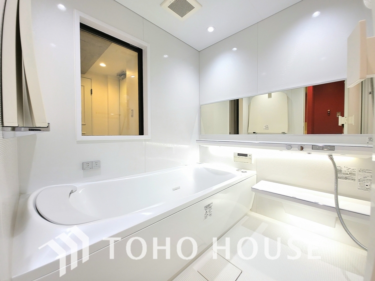 風呂 ガラス越しに玄関が見える、個性的なデザインの浴室です。広々とした浴槽で、足を伸ばしてゆったりとくつろげます。窓もあり、換気がしやすいです。