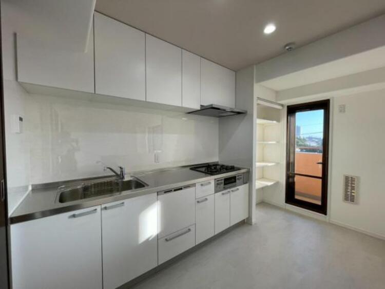 キッチン 食洗機付きのシステムキッチンは、バルコニーと繋がり開放的です。嬉しい吊戸棚収納付き！