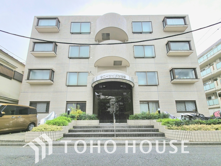 外観 緑豊かな植栽と、白を基調とした外壁が調和した清潔感あふれる外観です。マンションを取り囲む生垣が、プライベートな空間を確保します。