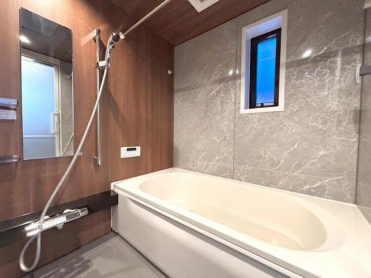 風呂 一日の疲れを癒してくれる浴室。高級感あるカラーと大きさ・柔らかな曲線で構成された半身浴も楽しめるバスタブが心地よさをもたらしてくれる落ち着いた空間です。 