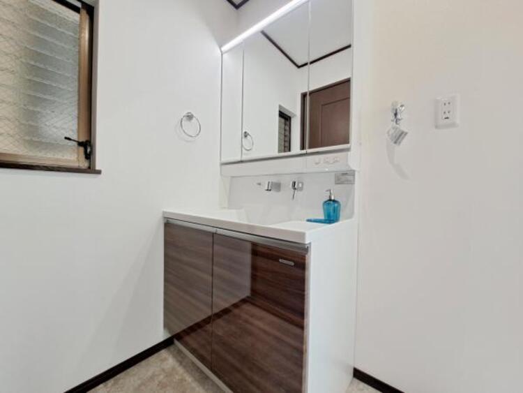 洗面 三面鏡の裏は機能的な収納を配置。コンセントも付いているため電動シェーバーや電動歯ブラシも収納できます。 