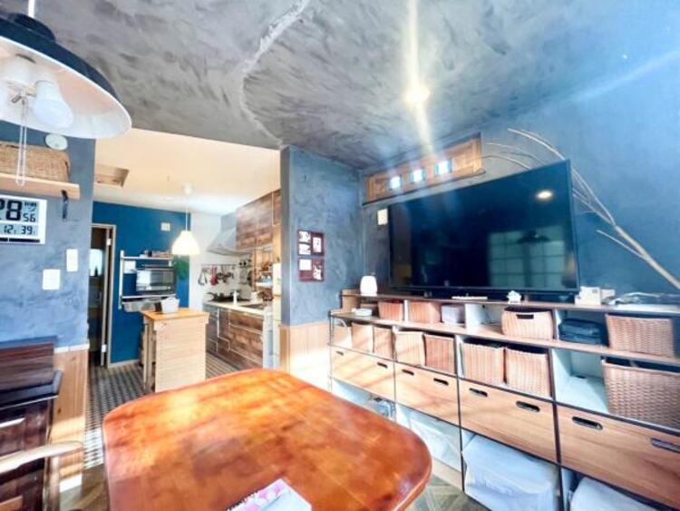 居間 木のテーブルやアンティーク調の照明が映える、落ち着いた色味の内装。 陽射しが入る窓際のスペースで、穏やかな時間をお過ごしいただけます。