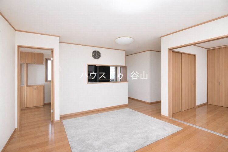 居間 対面キッチン越しに空間全体を見渡しやすく、隣室ともつなげて使える開放感のあるリビングです。