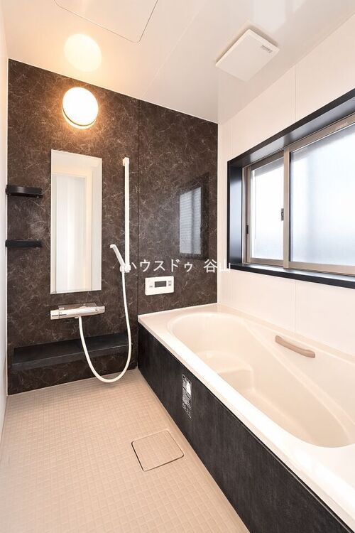 風呂 窓付きで換気しやすく、落ち着いたアクセントパネルが印象的な浴室空間です。